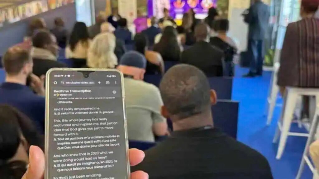 Speaker delivering a keynote with live AI translation running on the stage display